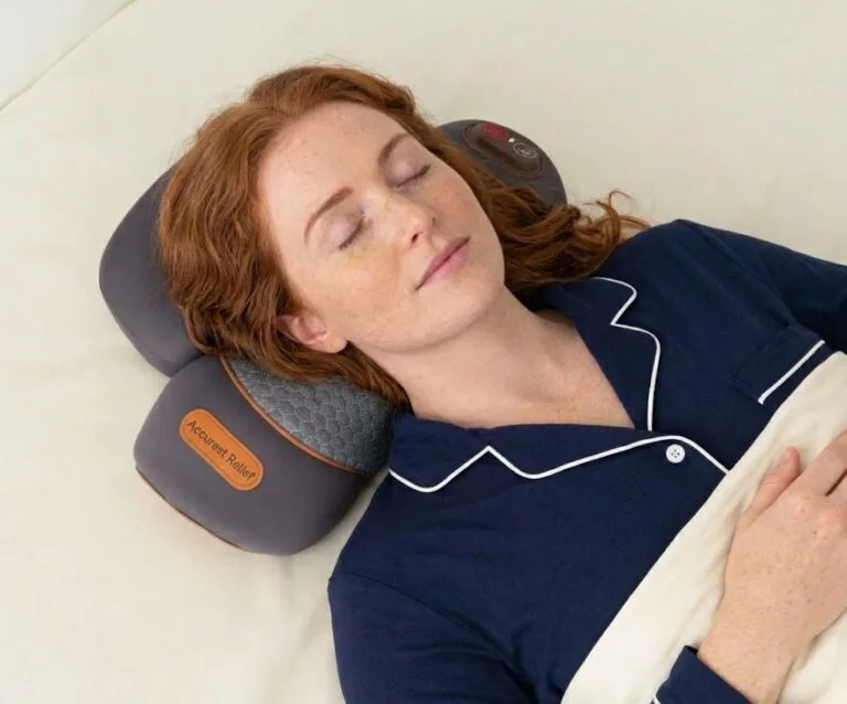 Person on sofa with pillow, phone face-down beside them